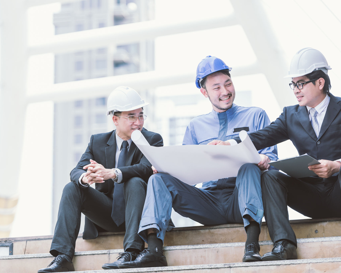 Engineers reviewing blueprints on construction site.